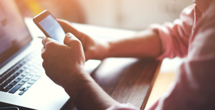 Man researching the differences between secured debt and unsecured debt on his cell phone